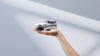 DJI Mini 4k drone folded in person's hand against a white background
