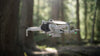 Mini 4 Pro drone flying with forest in background