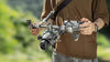 Man operating Tila Mavic 4 Pro rig in a natural setting