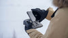 A person holding the DJI RC Pro 2 controller with a snowy background