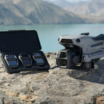 DJI Air 3s grey drone and open ND filter set on a rocky surface with a mountainous background
