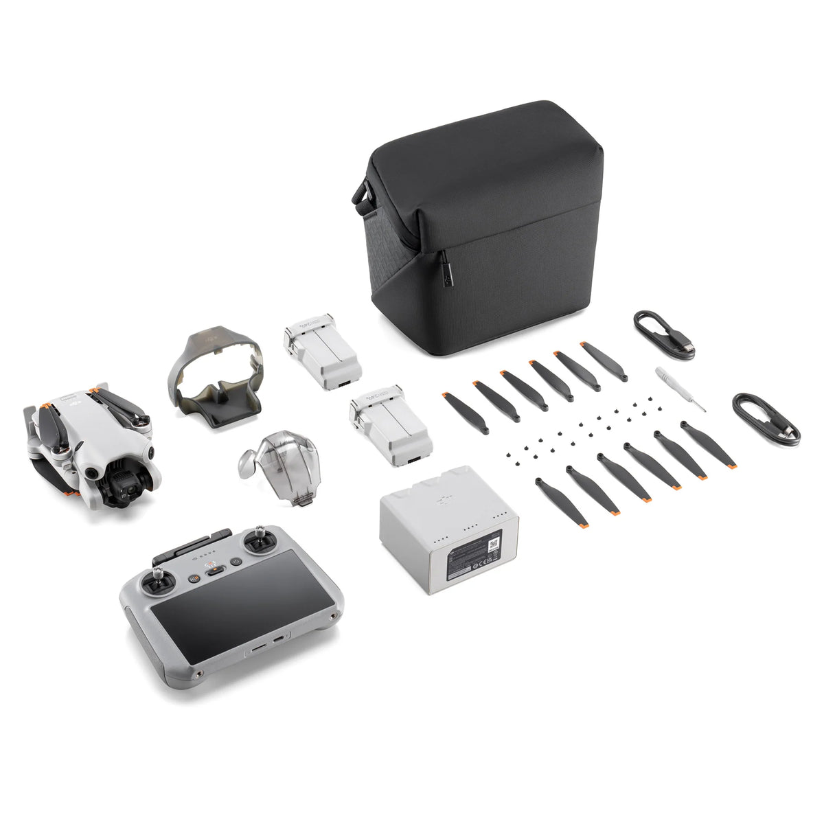 Mini 4 Pro drone with RC 2 remote controller, multiple batteries, propellers and cables on a white background