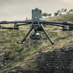 Large enterprise drone with H30T camera sensor payload flying over a natural landscape with a blurred background