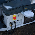 Closeup of red button and cables on the DJI Dock 3 station in an outdoors setting