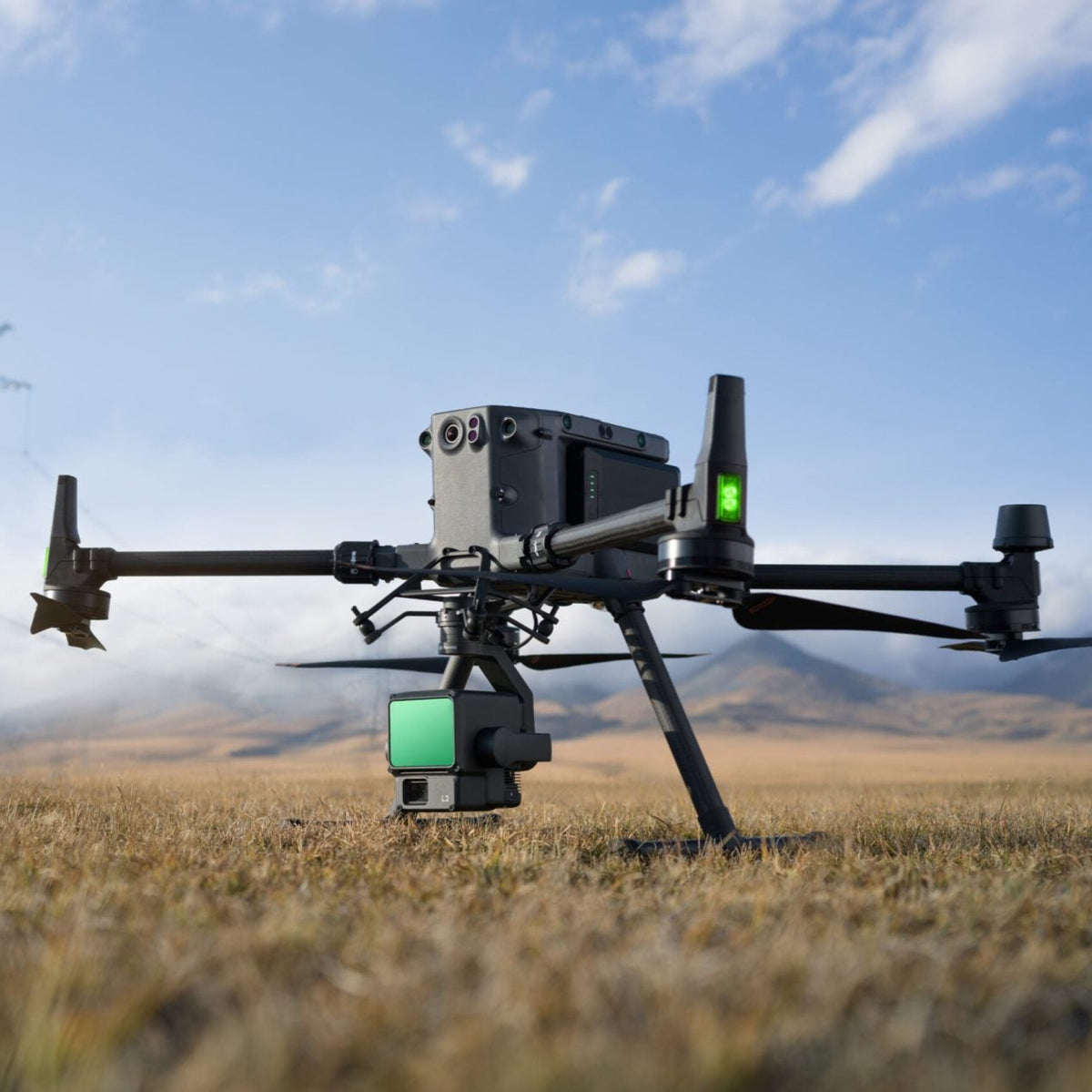 DJI Zenmuse L2 payload attached to Matrice enterprise drone on the grass with mountainous background