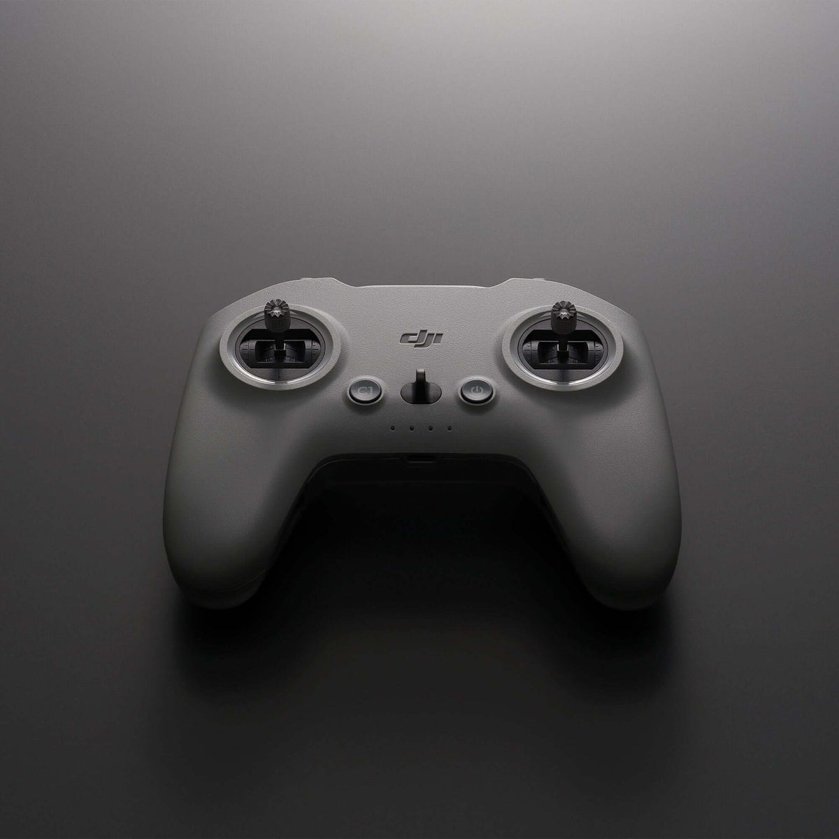 Grey FPV remote control with DJI logo front top-down view on a dark background