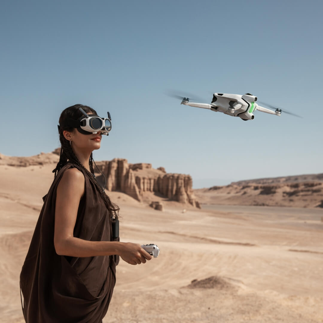 Girl in a desert landscape with goggles and hovering Antigravity A1 drone