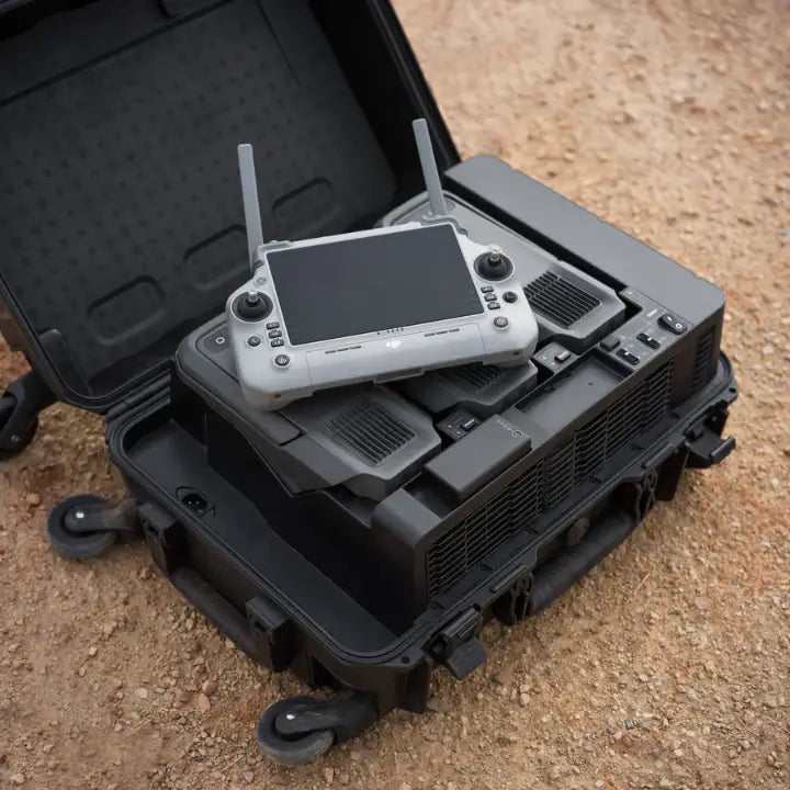 Enterprise drone controller on top of an open black battery station case on a sandy surface