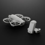 Two white batteries and DJI Neo drone on a dark background