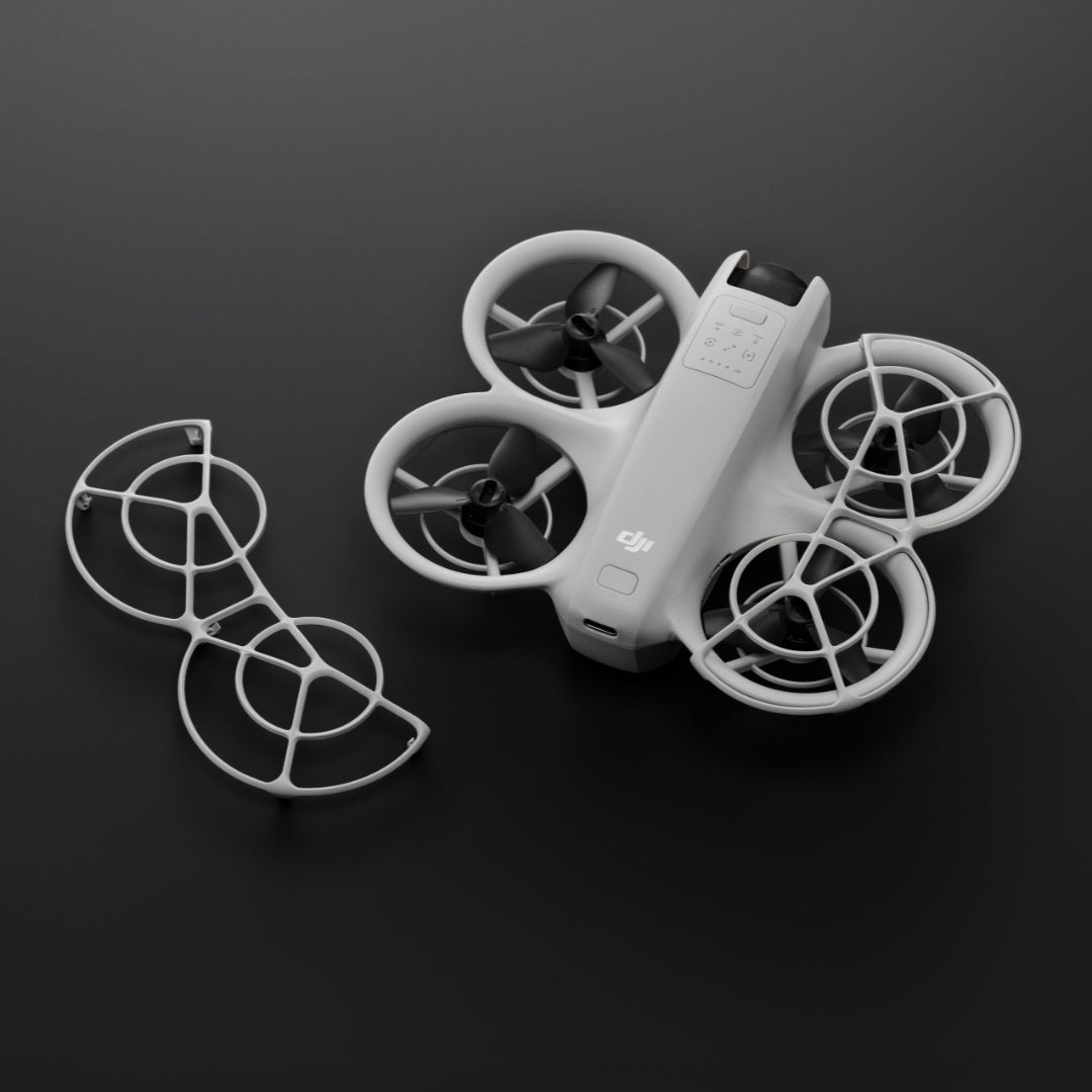 A pair of propeller guard and DJI Neo drone shown at birds-eye view on a dark background
