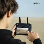 Man using an RC Pro Enterprise drone controller with a screen displaying a desert landscape