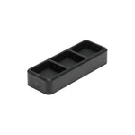 Black rectangular device with three charging compartments on a white background