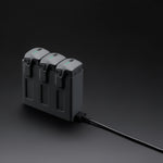 DJI Mavic 4 Pro black parallel charging hub 45-degree front left view on dark background