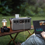 Portable Power 1000 V2 station with a laptop, camera and lantern on a table outdoors