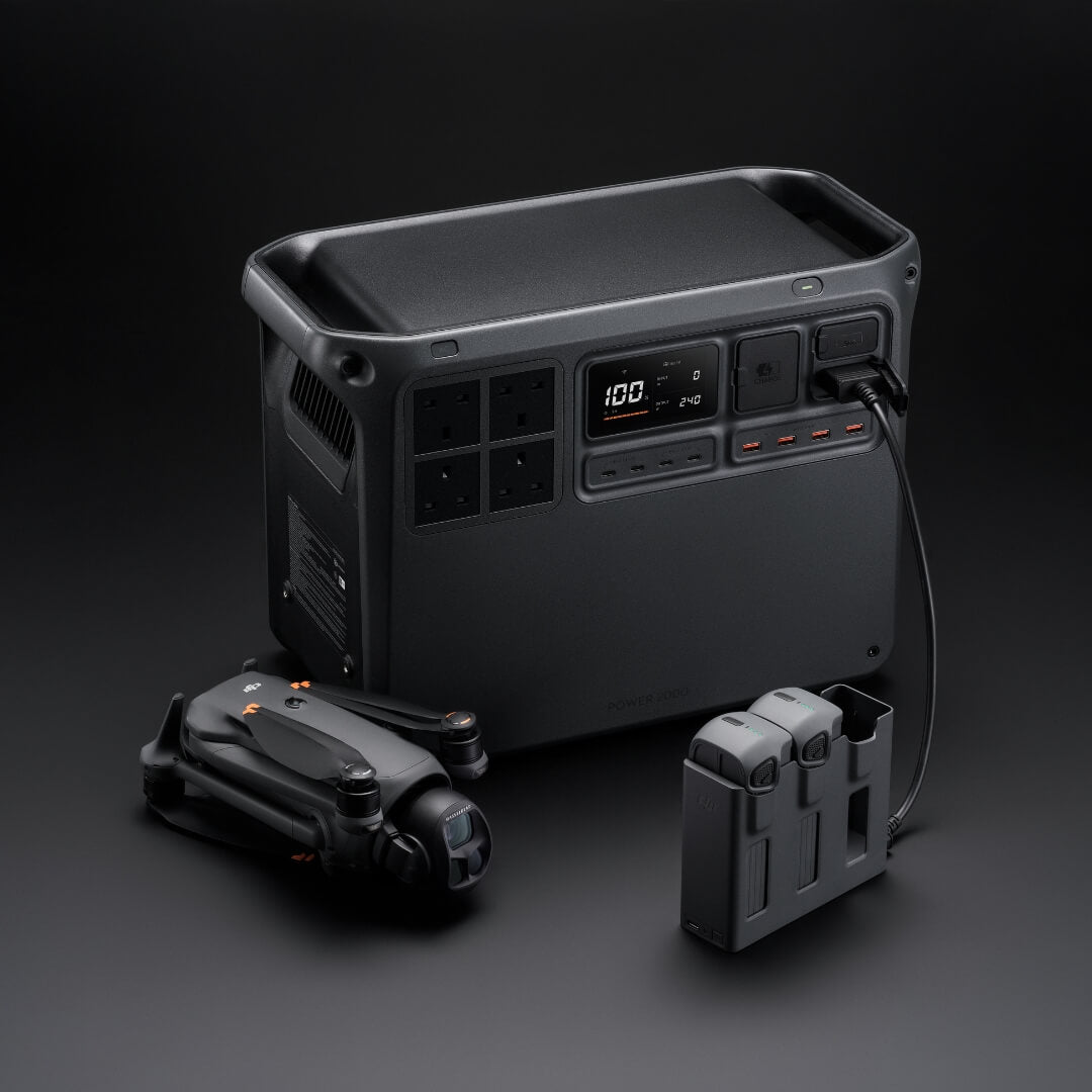 Grey portable Power 2000 station with a drone and battery charging hub on a dark background