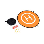Orange target with white 'H' symbol, black bag, red reflective strips and yellow grounding nails on a white background
