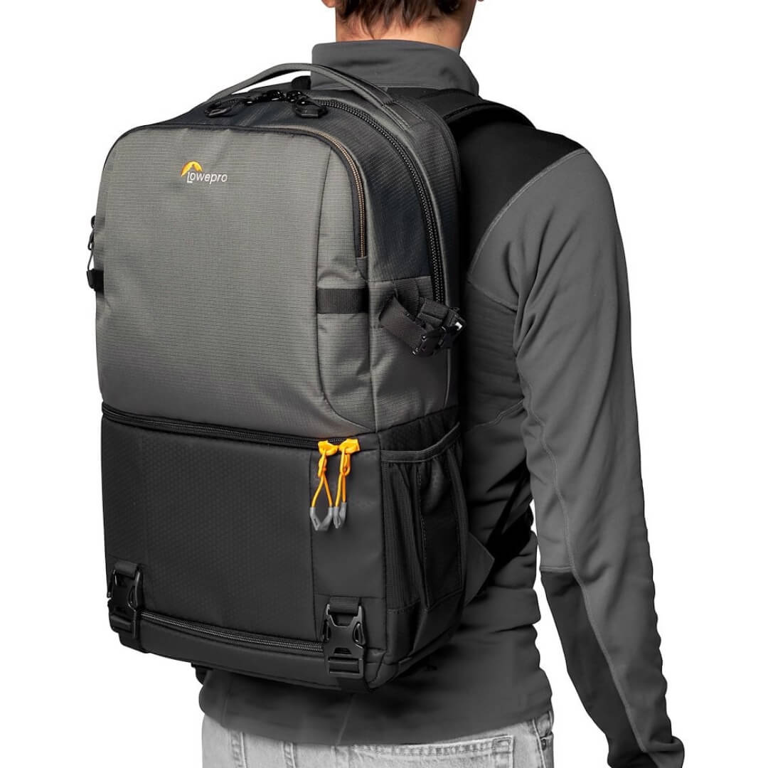 Person wearing a grey backpack with a visible Lowepro logo on a white background