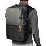 Person wearing a grey backpack with a visible Lowepro logo on a white background