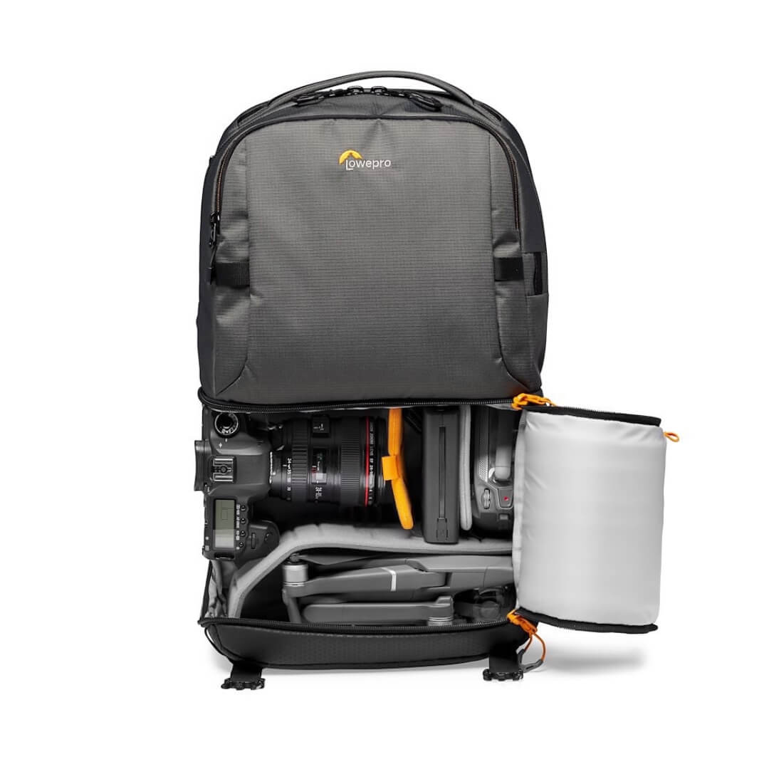 Grey camera backpack with compartments open on a white background