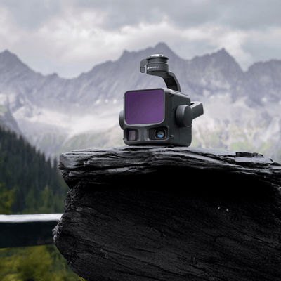 Camera on a rock with mountains in the background