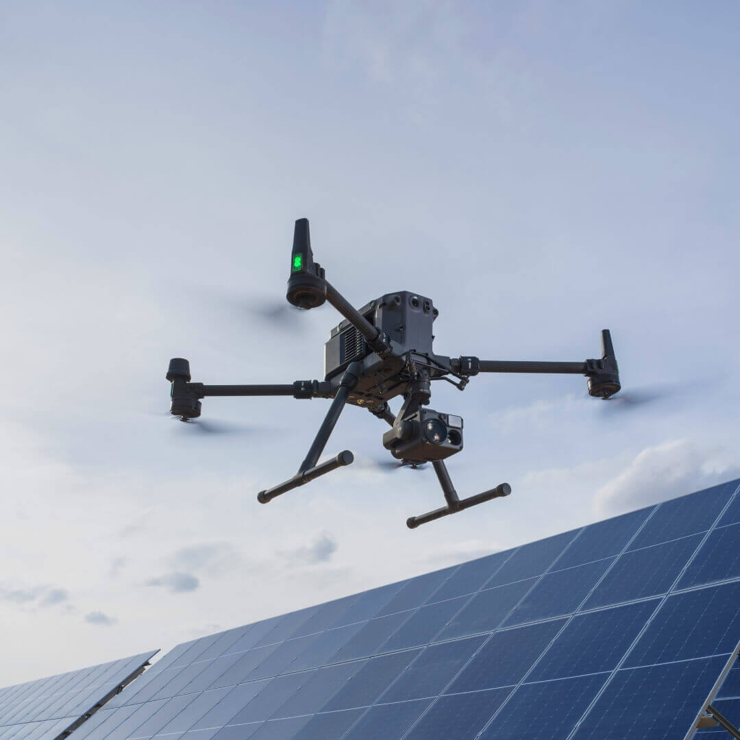 Drone flying over a solar panel with a clear sky background