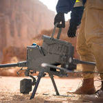Person inserting DJI TB100 battery into a M400 enterprise drone in a desert setting