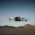 DJI Matrice 4E drone flying over a desert landscape with mountains in the background