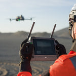Person operating a drone with a remote controller in an outdoor setting