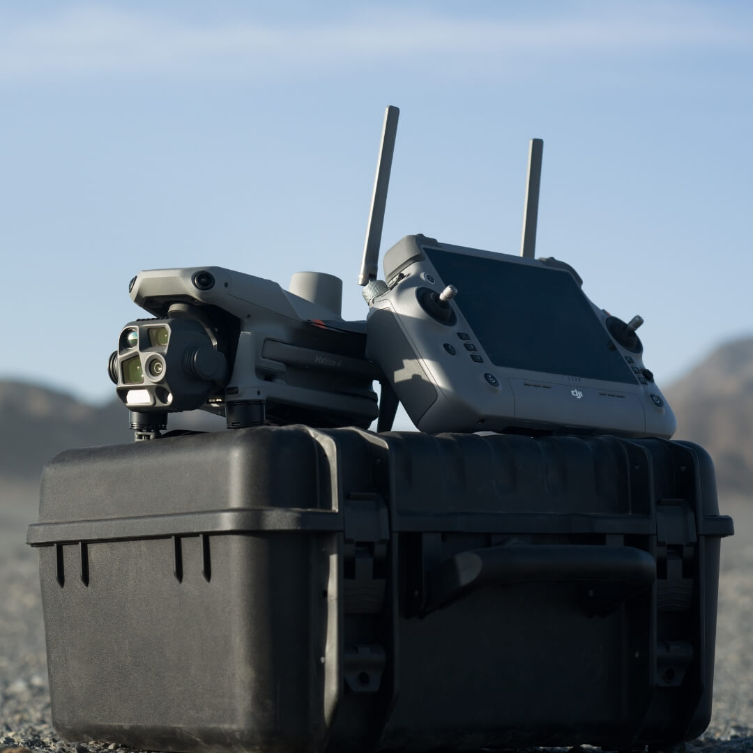 DJI Matrice 4T drone and remote control on a black hard case with a mountainous background