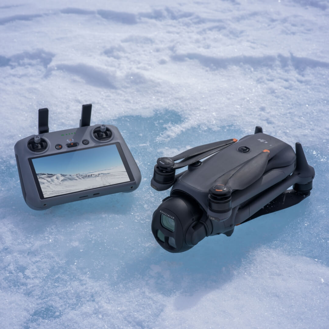 DJI Mavic 4 Pro grey drone folded and RC 2 remote controller on a snowy surface