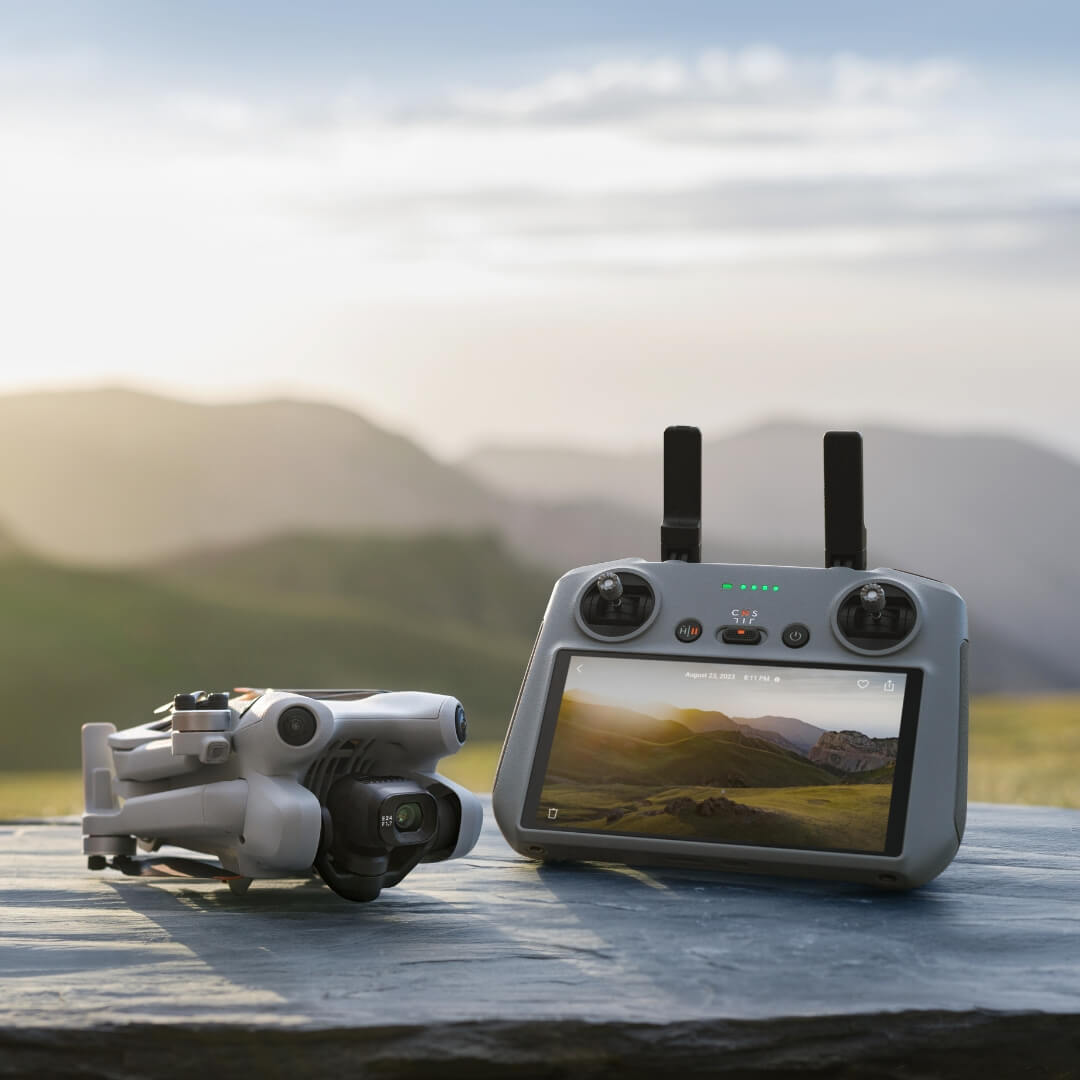 DJI Mini 4 Pro drone folded and RC 2 remote control with a scenic background