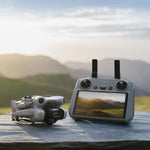 DJI Mini 4 Pro drone folded and RC 2 remote control with a scenic background