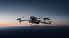 DJI Air 3s grey drone unfolded on a smooth surface with a sunset background