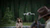 Woman operating the Mini 4 Pro drone with trees in the background accompanied by a man in the foreshot with his horse