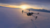 DJI Mavic 4 Pro drone flying in snowy landscape with person stood in the background