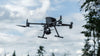 DJI Matrice 350 RTK drone flying surrounded by trees