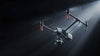 DJI Inspire 3 drone flying against a dark background with a spotlight on it
