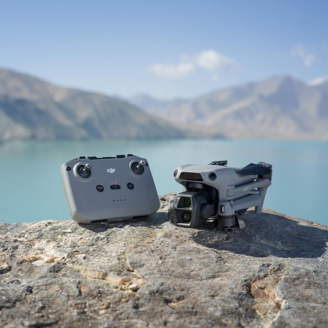 DJI Air 3S drone and RC-N3 controller on a rock with a mountainous landscape in the background