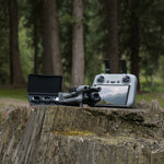 Mini 5 Pro drone with RC 2 controller and ND filter set on a wooden stump with a forest background