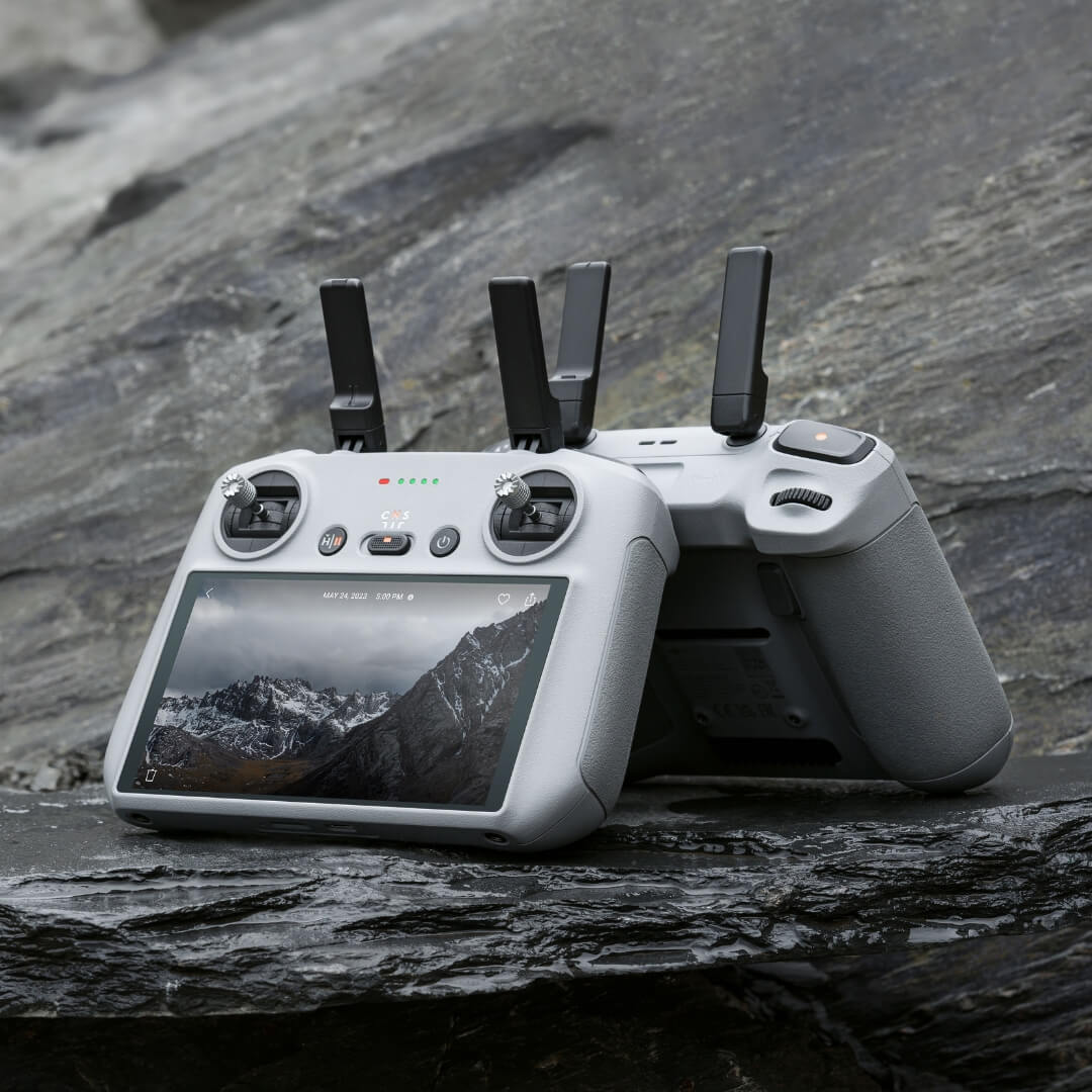 DJI RC 2 drone remote controllers with screen on a rocky surface
