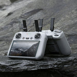 DJI RC 2 drone remote controllers with screen on a rocky surface